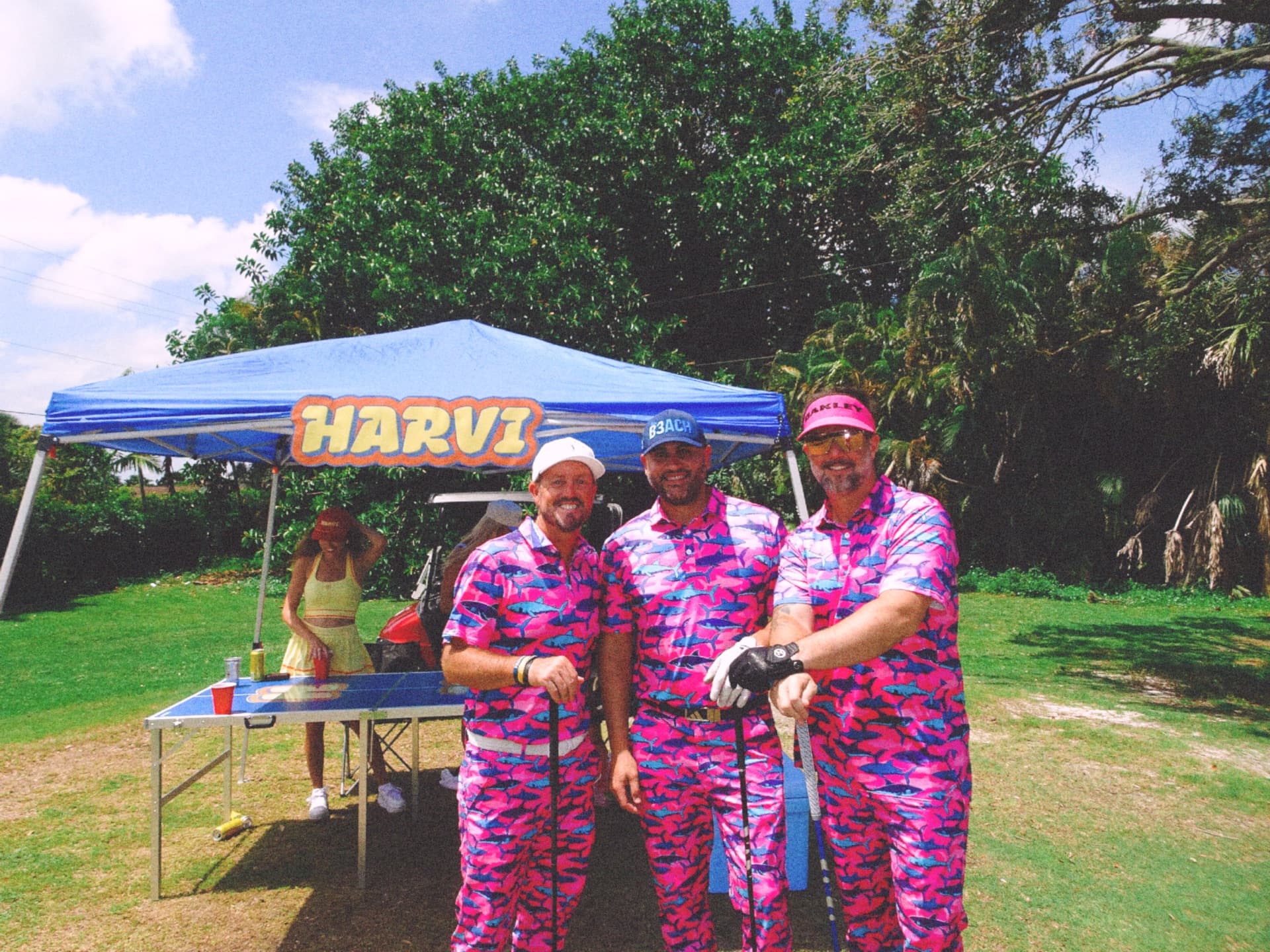 Group of business professionals laughing together during a networking golf tournament