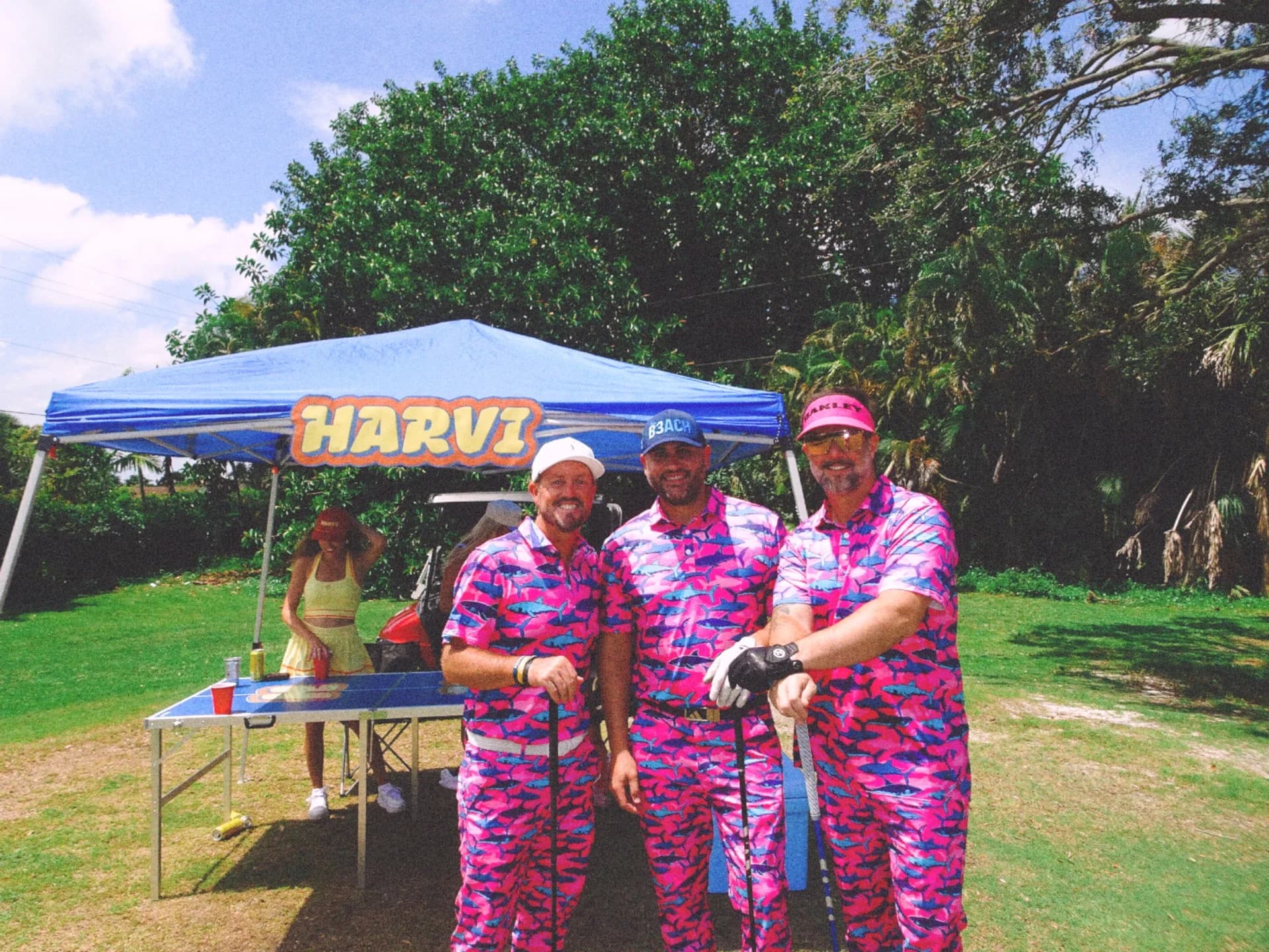 Business professionals laughing together during a golf tournament.